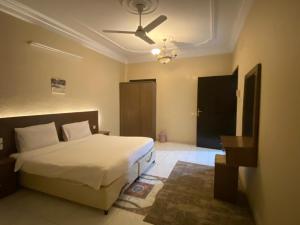 - une chambre avec un lit et un ventilateur de plafond dans l'établissement فيفيندا أحلى مكان خميس مشيط, à Khamis Mushait