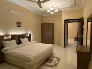 - une chambre avec un grand lit et un ventilateur de plafond dans l'établissement فيفيندا أحلى مكان خميس مشيط, à Khamis Mushait