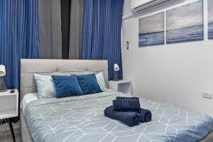 a bedroom with a large bed with blue pillows at IB Properties Suites in Jerusalem
