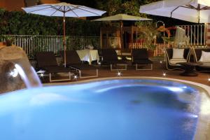 a large blue swimming pool with chairs and umbrellas at Hotel La Pigna in Marina di Pietrasanta