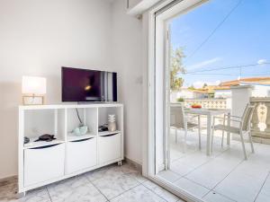 - un salon avec une télévision et une porte coulissante en verre dans l'établissement Apartment Bahia 58 by Interhome, à Empuriabrava