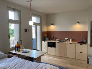a kitchen with a bed and a table in a room at Arbio I Lax Apartments in Leipzig