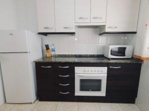 a kitchen with a white refrigerator and a microwave at Villa Villa Mallorca by Interhome in Miami Platja +21 photos