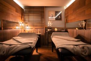 - 2 lits dans une salle de thérapie avec bougies dans l'établissement Hôtel Diana Restaurant & Spa by HappyCulture, à Molsheim
