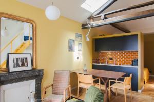 eine Küche und ein Esszimmer mit einem Tisch und Stühlen in der Unterkunft Le Grand Maulnes in Paris