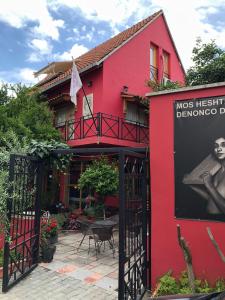 un bâtiment rouge avec un panneau sur son côté dans l'établissement Red Goat Hostel, à Tirana