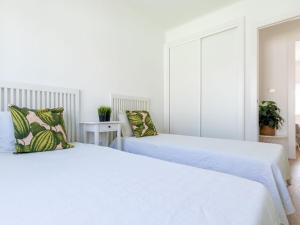 two beds in a room with white walls at Holiday Home Noelia by Interhome in Torredembarra