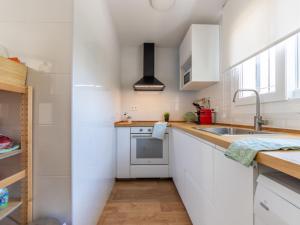 a kitchen with white cabinets and a sink at Holiday Home Noelia by Interhome in Torredembarra +25 photos