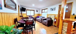 una sala de estar con una mesa y un sofá en Cabaña La Foresta, en Coyhaique