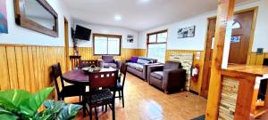 a living room with a table and a couch at Cabaña La Foresta in Coihaique