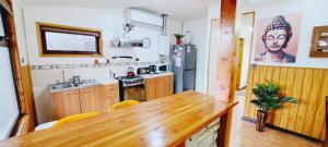 cocina con mesa de madera y nevera en Cabaña La Foresta, en Coyhaique