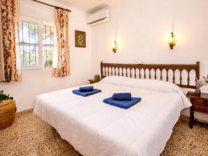 - une chambre avec un grand lit blanc et des serviettes bleues dans l'établissement Holiday Home Casa Moser by Interhome, à Jávea