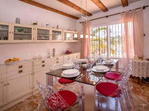 une salle à manger avec une table et des chaises rouges dans l'établissement Holiday Home Casa Moser by Interhome, à Jávea