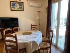 una sala da pranzo con tavolo, sedie e TV di Casa Minnana a Figari