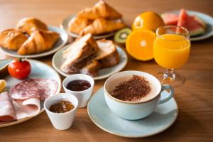 Hôtel Diana Restaurant & Spa by HappyCulture في مولسهايم: طاولة مع أطباق من طعام الإفطار وكوب من القهوة
