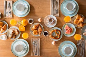 a table with plates of breakfast foods and eggs at H&ocirc;tel Diana Restaurant & Spa by HappyCulture in Molsheim