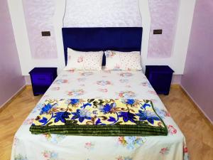 a bedroom with a bed with a blue and white bedspread at Dream House Sidi Ifni in Sidi Ifni