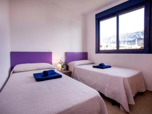 una camera con due letti con asciugamani blu di Apartment Sueños del Mar I-3 by Interhome a Denia