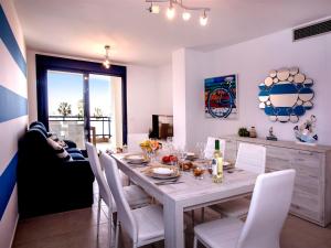 una sala da pranzo con tavolo e sedie bianche di Apartment Sueños del Mar I-3 by Interhome a Denia