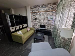 Vegueta Casa Los Girasoles في لاس بالماس دي غران كاناريا: غرفة معيشة مع أريكة صفراء وجدار من الطوب