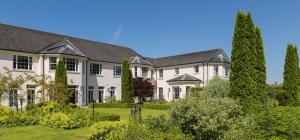 a large white house with trees in front of it at Nuremore Estate in Carrickmacross