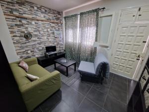 Vegueta Casa Los Girasoles في لاس بالماس دي غران كاناريا: غرفة معيشة مع أريكة خضراء وطاولة
