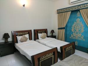 um quarto com 2 camas e uma cortina azul em White Palace Guesthouse em Islamabad