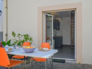 uma mesa com cadeiras de laranja e uma taça de fruta em Holiday Home Maison Des Lilas by Interhome em Quiberon