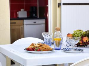 einen Tisch mit einem Teller Gebäck und Obst in der Unterkunft Holiday Home Le Moulin Neuf by Interhome in Pornic