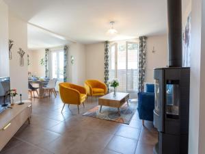 ein Wohnzimmer mit gelben Stühlen und einem Kamin in der Unterkunft Holiday Home Le Moulin Neuf by Interhome in Pornic
