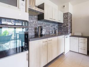 eine Küche mit weißen Schränken und einer Ziegelwand in der Unterkunft Apartment Rivadour 2 by Interhome in Bayonne
