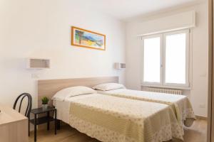 a white room with two beds and a window at Affittacamere Ceccarini in Riccione