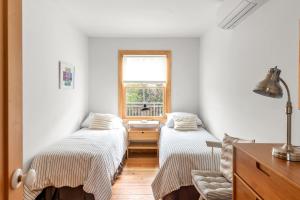 two beds in a room with a window at Huron Hideaway in Ocean Bay Park