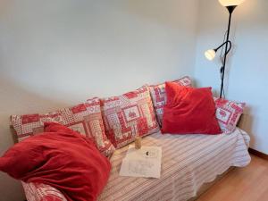 Zimmer mit einem Sofa mit roten Kissen und einem Tisch in der Unterkunft Studio les chalets du soleil by Interhome in Saint-Gervais-les-Bains