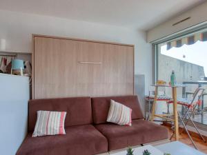 a living room with a brown couch and a table at Studio Le Bali-3 by Interhome in La Ciotat