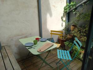 einen grünen Tisch und Stühle auf einer Terrasse in der Unterkunft ACCROCHE-COEUR MAISON de PECHEUR in Trouville-sur-Mer + 12 Fotos