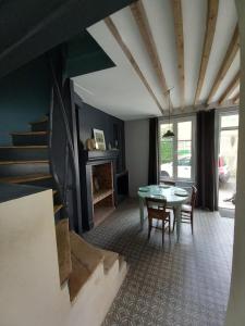 ein Esszimmer mit Tisch und Stühlen und einer Treppe in der Unterkunft ACCROCHE-COEUR MAISON de PECHEUR in Trouville-sur-Mer