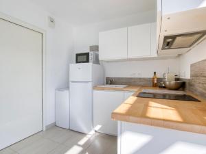 a kitchen with white appliances and a wooden counter top at Studio Le Domaine de la Mer by Interhome in Saint-Cyr-sur-Mer