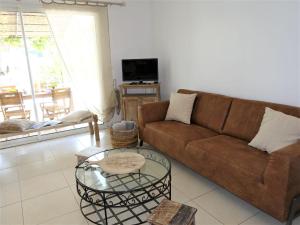 a living room with a couch and a table at Apartment Le Vallon des Chenes by Interhome in Saint-Aygulf