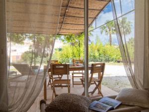 ein Esszimmer mit einem Tisch und einem großen Fenster in der Unterkunft Apartment Le Vallon des Chenes by Interhome in Saint-Aygulf