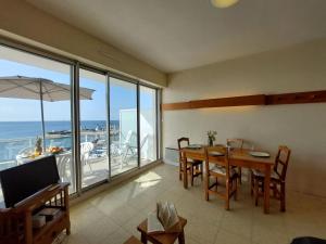 a dining room with a table and a view of the ocean at Studio Atlantique-3 by Interhome in Carnac