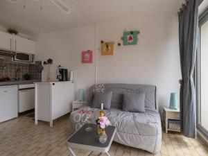 ein kleines Wohnzimmer mit einem Sofa und einem Tisch in der Unterkunft Studio La Frégate-13 by Interhome in Le Grau-du-Roi