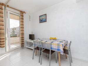 une salle à manger avec une table, des chaises et une télévision dans l'établissement Apartment Cala Gabriel by Interhome, à Vinaròs