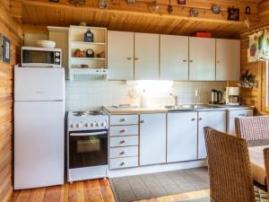eine Küche mit einem weißen Kühlschrank und einer Spüle in der Unterkunft Holiday Home Kotimökki by Interhome in Sotkamo