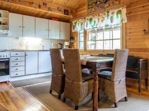 een keuken met een houten tafel en stoelen bij Holiday Home Kotimökki by Interhome in Sotkamo