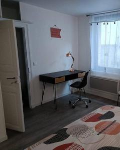 a bedroom with a desk and a lamp on a table at Charmante maison de ville Les 2B46 in Cahors