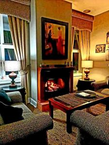 a living room with a fireplace and a table at Silver Mist Guest House, Country Inn and Herberg in Kaapsehoop