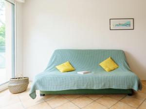 - un canapé vert avec deux oreillers jaunes dans l'établissement Apartment Arnaïa by Interhome, à Anglet