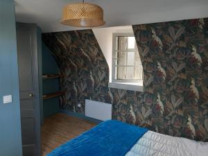 ein Schlafzimmer mit einem blauen Bett und einem Fenster in der Unterkunft ACCROCHE-COEUR MAISON de PECHEUR in Trouville-sur-Mer