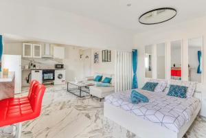 een woonkamer met een bed en een rode stoel bij Appartement climatisé à Béziers avec Jacuzzi & Rétroprojecteur - Le Palais des Glaces in Béziers